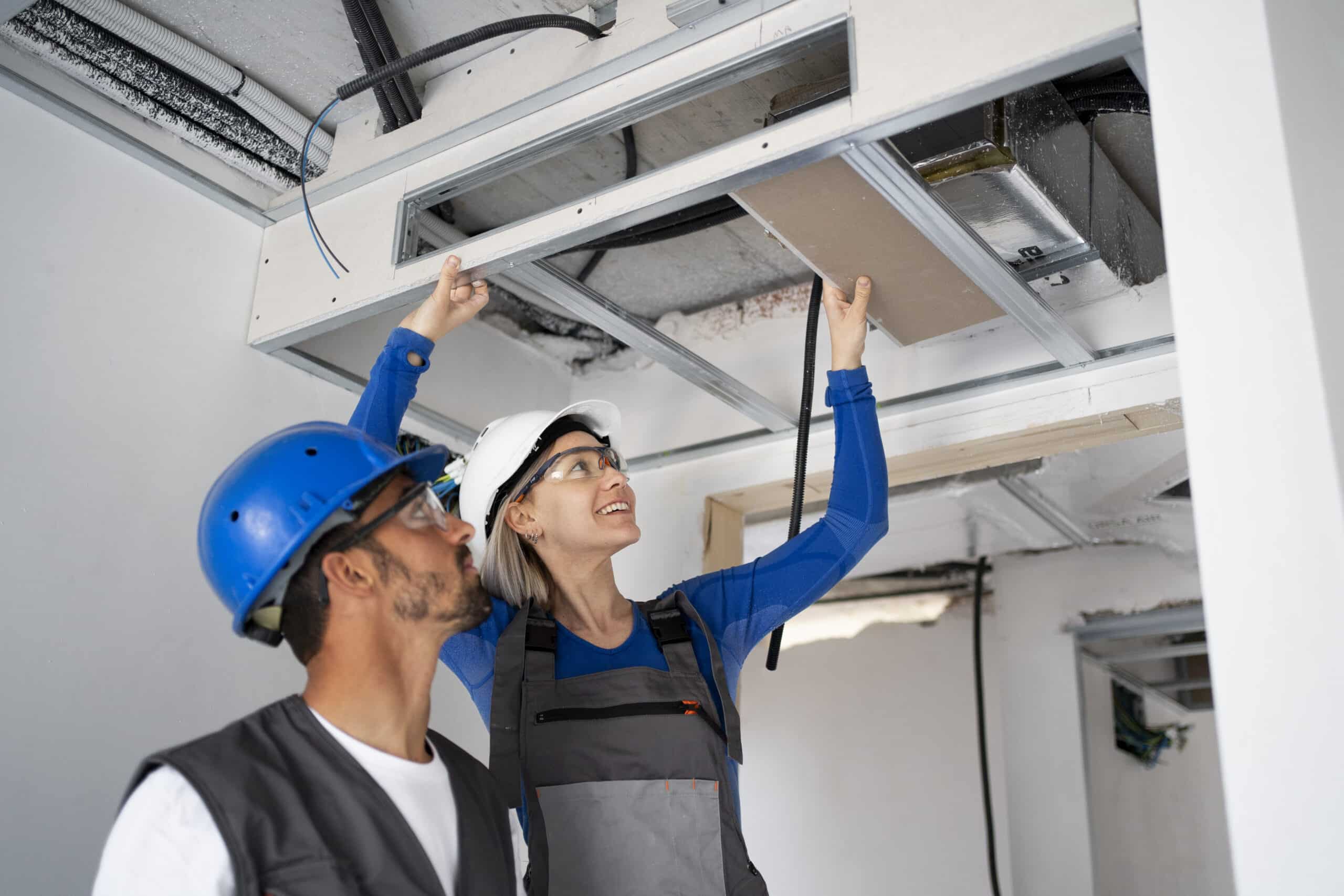 Technicians installing a commercial air conditioning system in a modern building